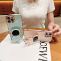 Miniatyrbillede 3 af 6: 6D Elektroplettet Astronaut Skjult Stativ Etui til iPhone Kvinder Astronaut Foldbart Stativ iPhone Etui med Kamera Beskytter Blød TPU Stødsikker Bumper Pink iPhone 15 Pro