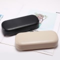 Miniatyrbilde 2 av 5: En svart og en beige hardt glass etui