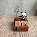 Pikkukuva 5 / 5: Puinen musiikkilaatikko pöytäkalenteri panda-patsaalla makuuhuoneen kaapin työpöydälle