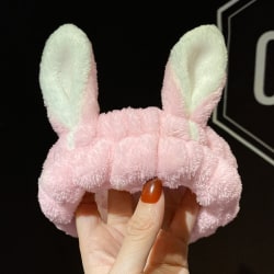 Ett rosa pannband för kaninöron för tvätt eller smink