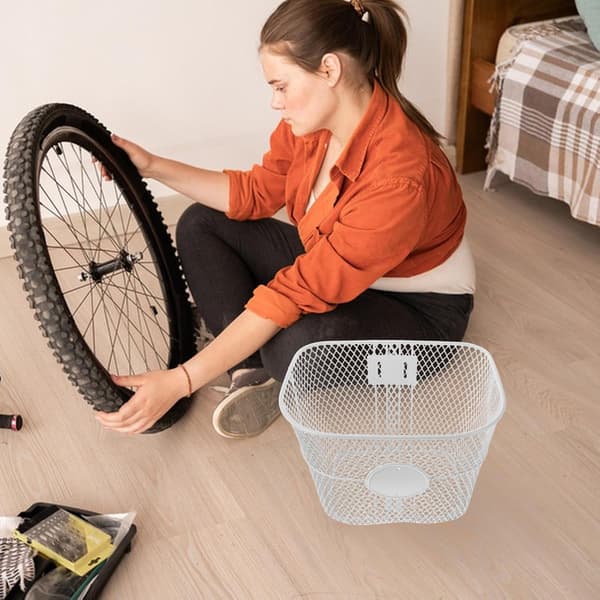 Vit cykelkorg framtill med nätstruktur och lättviktskonstruktion i järn