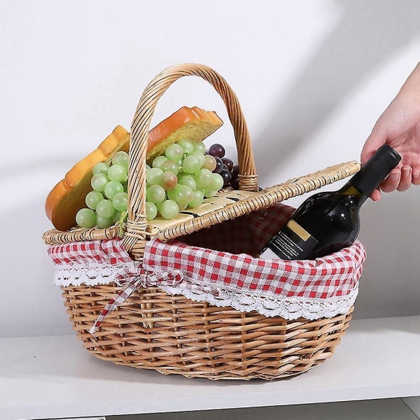 Lantlig flettet picnic kurv med låg og håndtag og foder til picnic, fester og grill