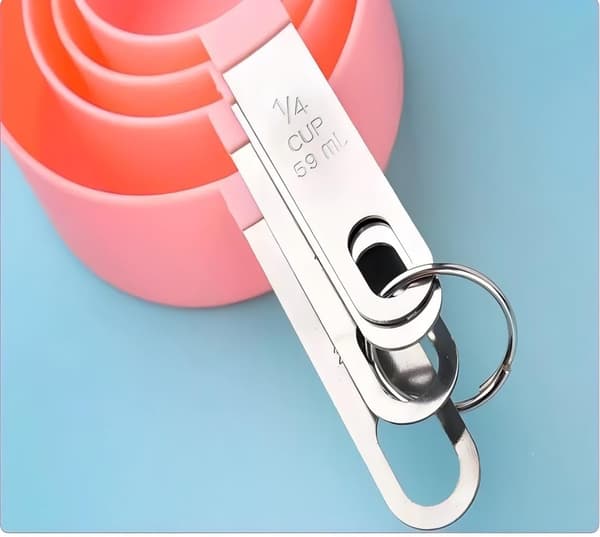 8 stk. målebeger og skjesett, stablebart håndtak i rustfritt stål, liten teskje med plasthode (rosa)
