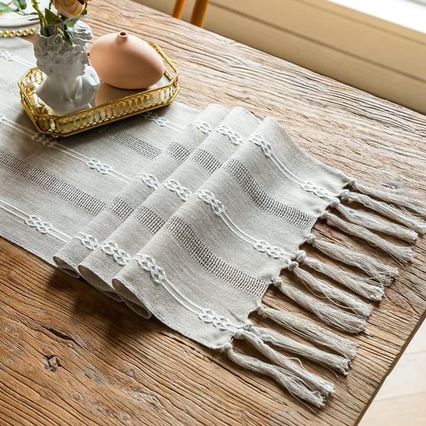 Grå bordløper med håndlagde dusker i lin med uthulet brodert T