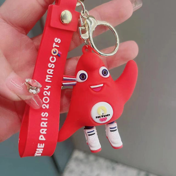 Olympisk Phrygisk nøglering - Officiel maskot for de olympiske lege i Paris 2024 - Souvenir nøglering i form af en rød phrygisk hat - PARIS 2024 Olympi