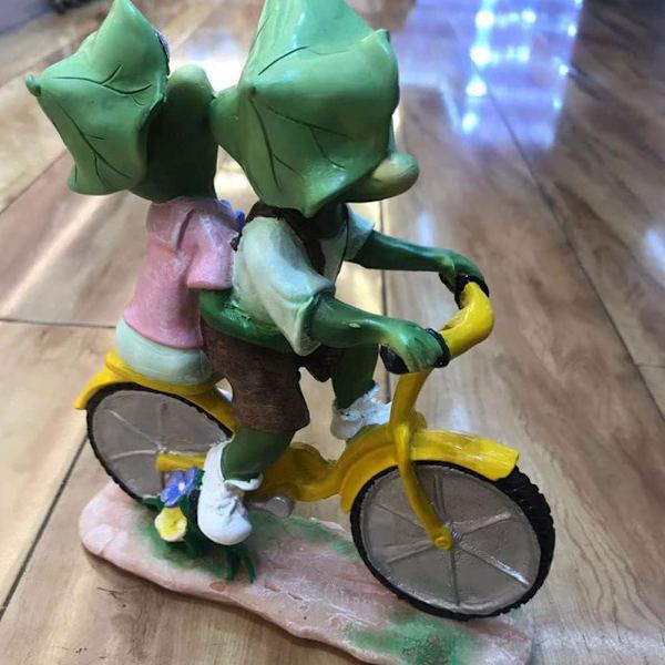Trädgårdsdekoration av hartsgroda, roligt hartspar med cykelhantverk