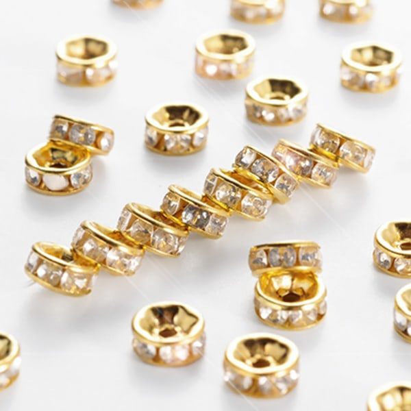 6mm strassringar/distanser, guld/klar, 50 guld