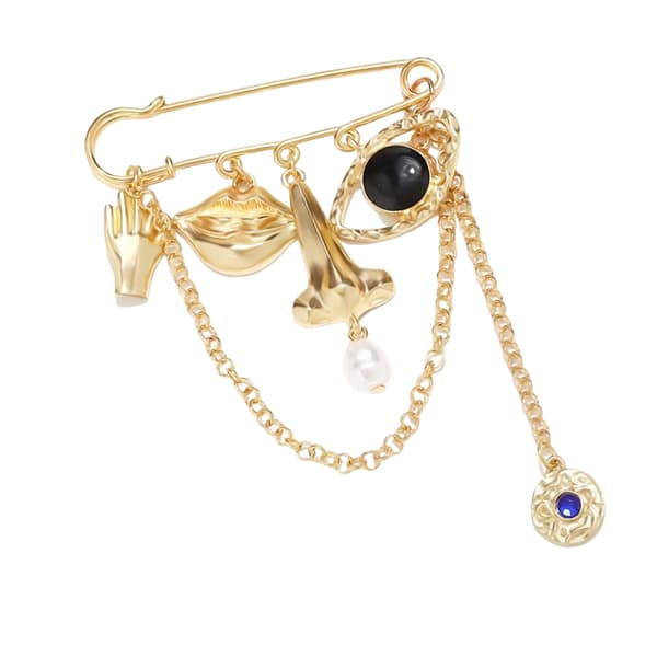 Ukonventionel udtryksfuld ansigtsbroche til edgy styling