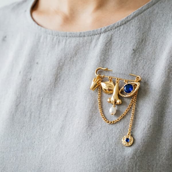 Ukonventionel udtryksfuld ansigtsbroche til edgy styling