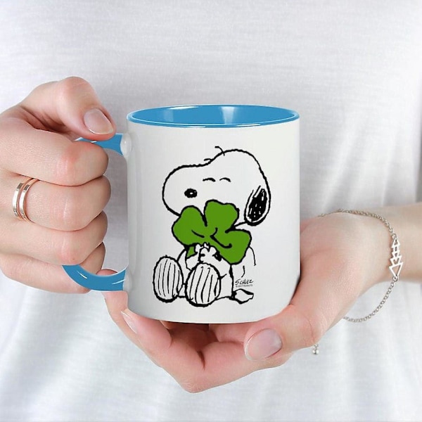 CafePress - Snoopy som klemmer kløver - 11 oz keramisk krus - Nyhetskaffe Tekopp - NDJ111