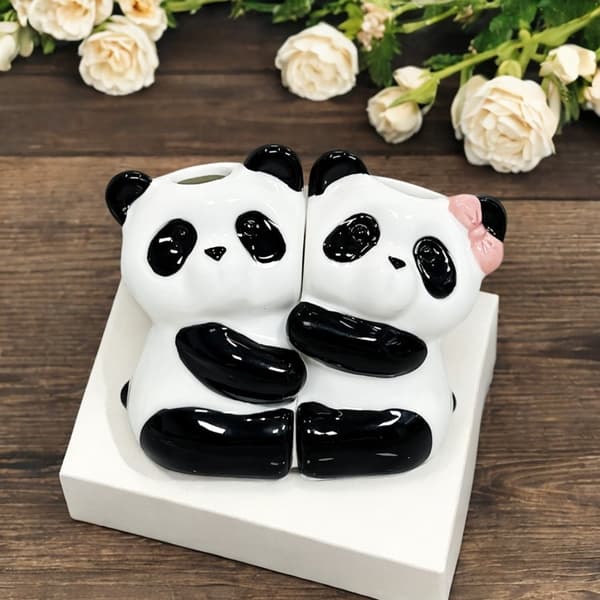 Kaksi keraamista pandaa halaa hammasharjatelinettä White