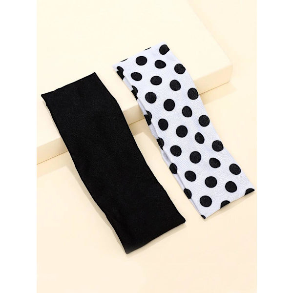 2 Stretch Hårband i polyester C:a 6 x 20 cm. 1 Svart 1 polka dot