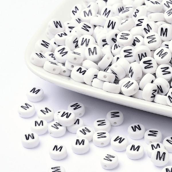 100 kpl Valkoisia akryylikirjahelmiä "M" mustalla tekstillä