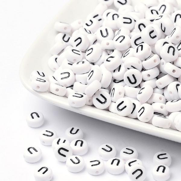 100 kpl Valkoisia akryylikirjahelmiä "U" mustalla tekstillä