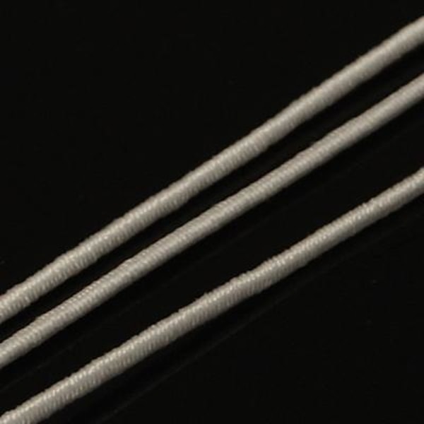 Ca 25 m. Hvit stoffkledd elastisk tråd 1 mm. Ø i diameter