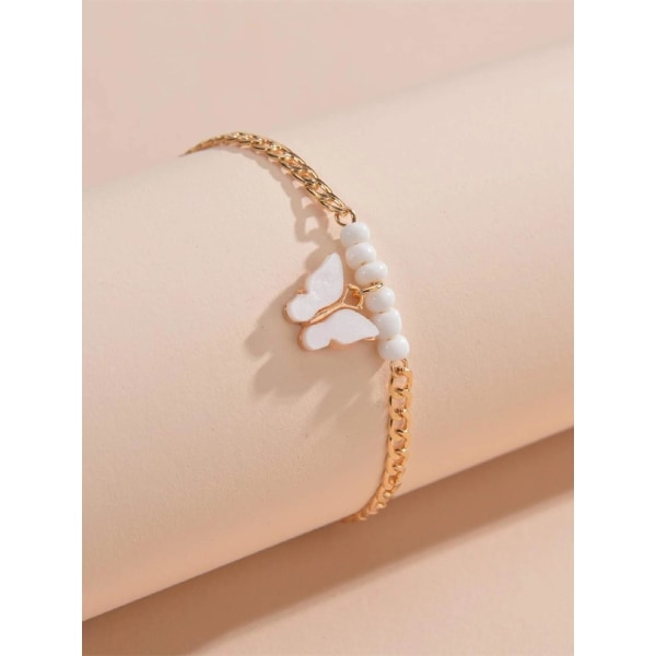 Gullbelagt fotlenke med hvite perler og hvit emaljert sommerfugl