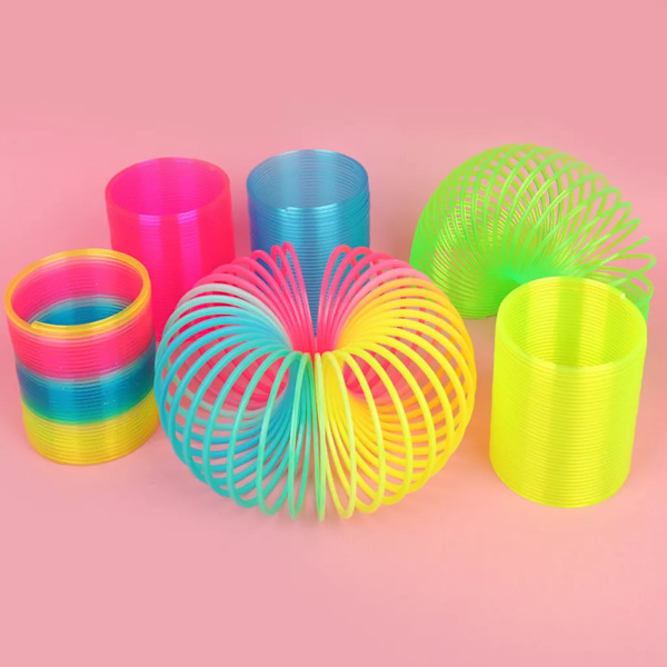Regnbågsformad spiralfjäderleksak, klassisk nyhet och färgglad neonplastleksak, festtillbehör för pojkar och flickor