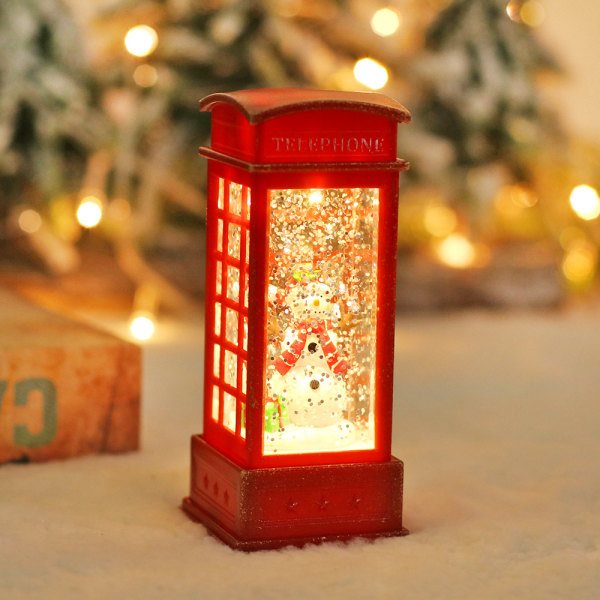 Den første glødende julesnømannen i telefonkiosk, rød telefonkiosk. Julevindlykt krystalllys