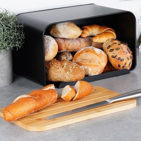 Tilava musta metallinen leipälaatikko bambuleikkuulaudalla