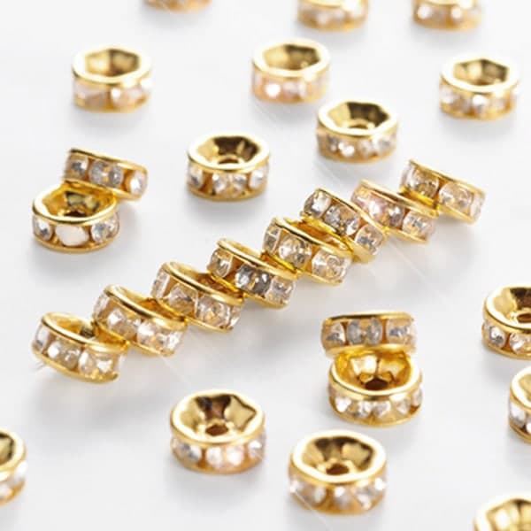 6 mm strassringe/afstandsstykker, guld/klar, 50 guld