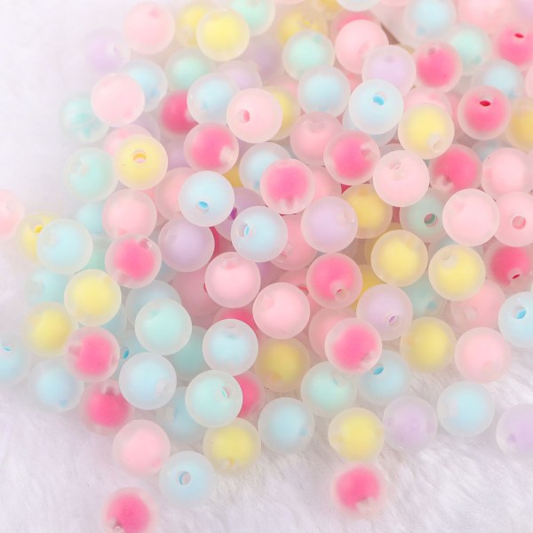 Ett paket akrylfärgade pärlor i tre storlekar med en blandad