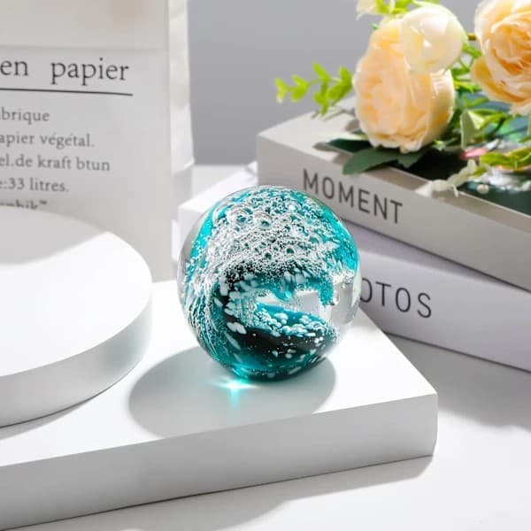 Handblåst glaskristallkula med vågdesign - ett dekorativt glassamlarobjekt.