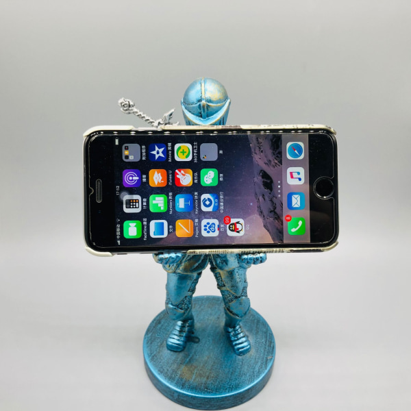 Hieno peli – Tyylikäs puhelinteline: Puun inspiroima Humanoidi-mobiiliteline ja peliohjaimen pidike elektropläterad blå riddare