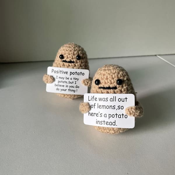 Rolig positiv potatis e ull stickad docka med positivt kort - stock B