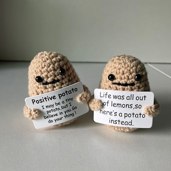 Rolig positiv potatis i ull, stickad docka med positivt kort