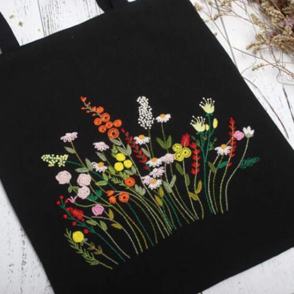 Svart broderikit i canvas med mönster och instruktioner Innehåller broderad väska med blommönster, broderiram i bambu, färgade trådar och Prosp