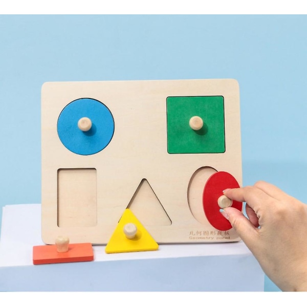 Barns kognitiva trähand som griper geometrisk pedagogisk leksak (C-stil)