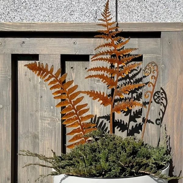 Delikate rustne blad på stake, rusten statue for hage og hjemmeparterre