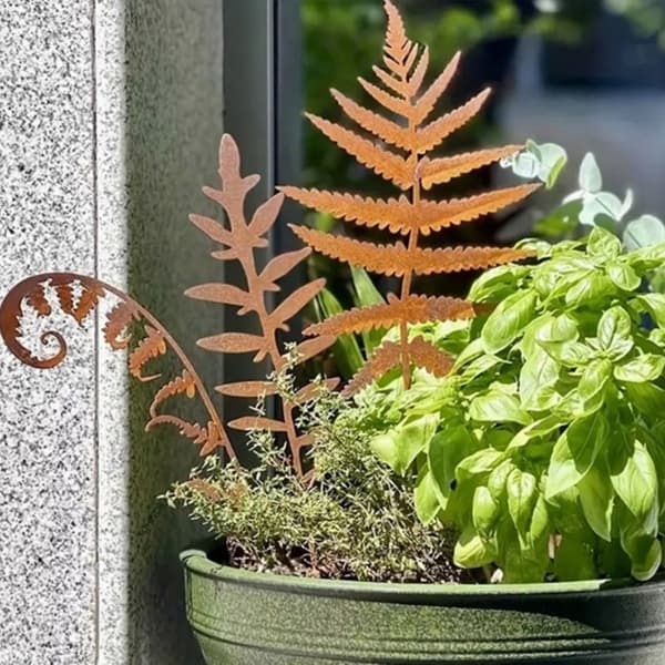 Delikate rustne blad på stake, rusten statue for hage og hjemmeparterre