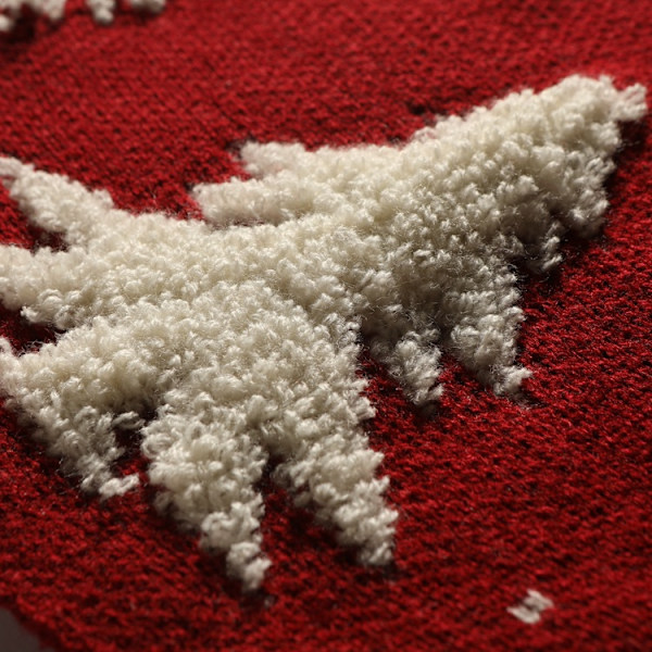 Stickad julgransklänning med broderade snöflingor och renar