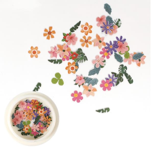 Manikyrlappar i träpulp med färgglada blommor och tusensköna
