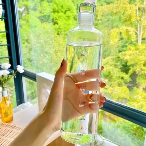 Lasillinen vesipullo, jonka ajan merkitsee 500 ml läpikuultavaa läpinäkyvä