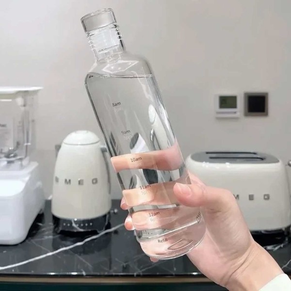 Lasillinen vesipullo, jonka ajan merkitsee 500 ml läpikuultavaa läpinäkyvä
