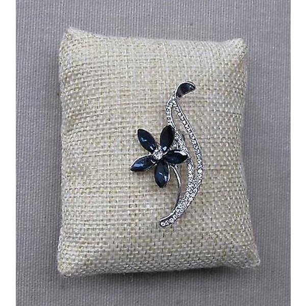 Generisk broche i sølvstål med blomstermotiv, hvide rhinsten og blå østrigske krystaller.