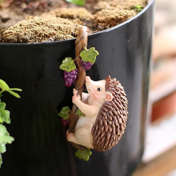 Sød klatrende pindsvinefigur blomsterpotte-krammer