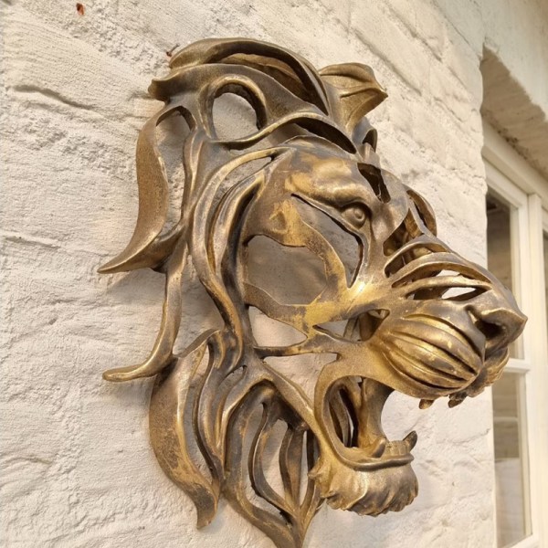 Suuri, seinään kiinnitettävä leijonanpäällinen taideveistos kultahartsileijonanpää