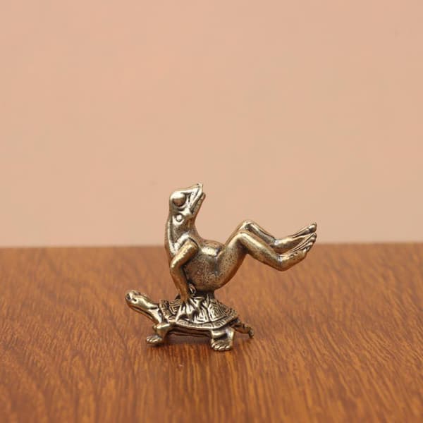 Messingfrø, der rider på skildpaddefigur, udsøgt retrohåndværk perfekt