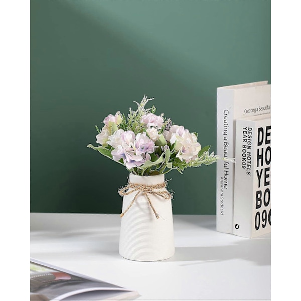 Europeisk vit keramisk vas dekorerad med torkade blommor