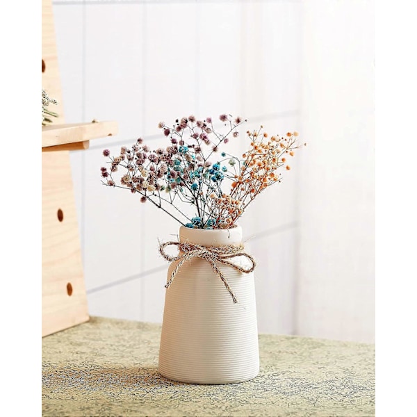 Europeisk vit keramisk vas dekorerad med torkade blommor