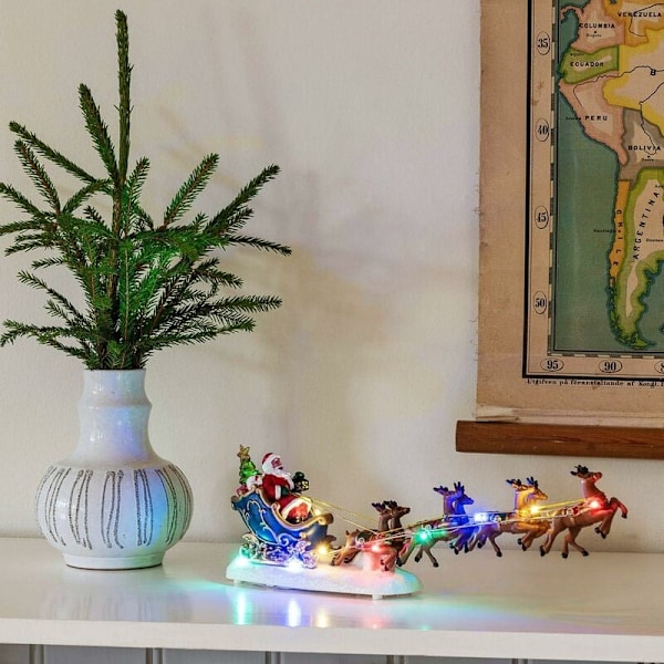 Ljusstark juldekoration som föreställer en tomte i sin släde dragen av renar, drivs av 3 AAA-batterier (ingår ej) och flerfärgad