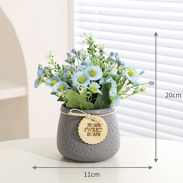 Liten kunstig daisy-blomst i keramisk potte for hjemmet