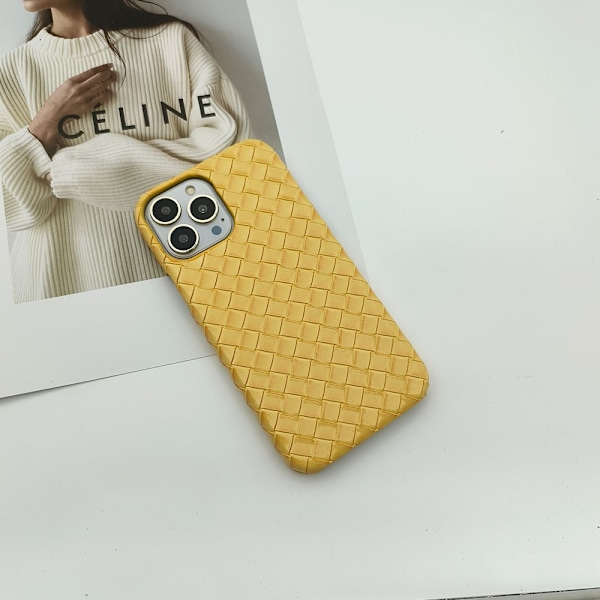 iPhone 15:n keltainen kotelo, jossa on kudottu nahkarakenne, on kostea ja kova