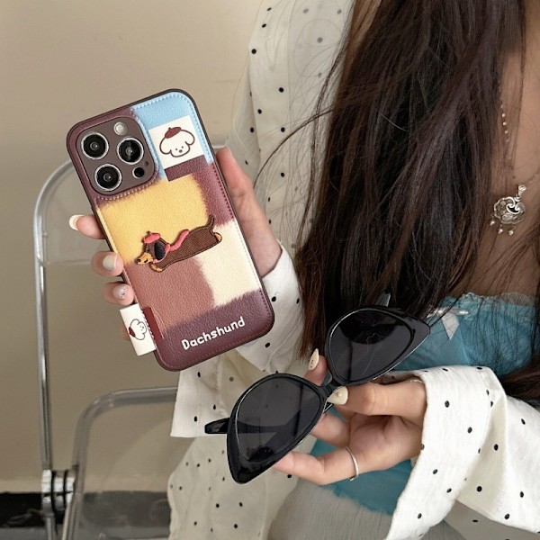 Kotelo iPhone 15 Promaxille, kontrastiväripinnat + juokseva mäyräkoira, retro sarjakuva, kontrastivärit, mäyräkoiran nahkakuvio