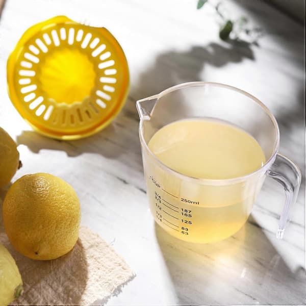 Stor manuell citronpress med mätkopp, gul citruspress i plast, juiceutbyte