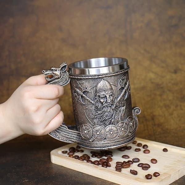 Øl- og kaffekrus i rustfrit stål med vikinge-skibsmotiv i bronze