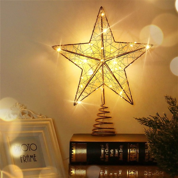 Stjernelys på toppen af ​​det gyldne juletræ juletræ